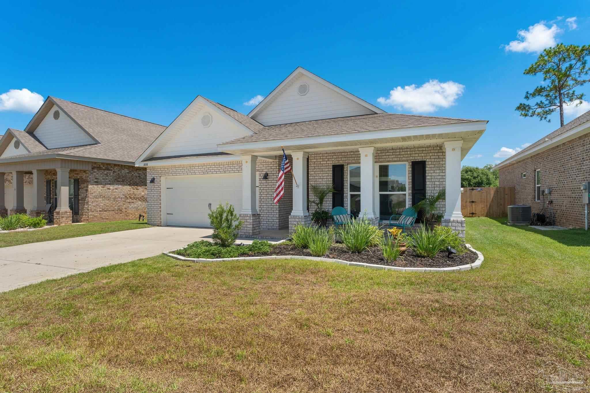 8038 Burnside Loop Pensacola, FL 32526 - Photo 3 of 44 a front view of a house with a yard and potted plants