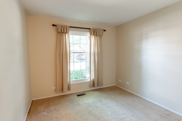 2610 Northampton Drive, Unit B1 Rolling Meadows, IL 60008 - Photo 9 of 16 an empty room with a window