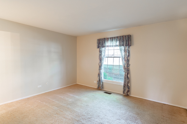 2610 Northampton Drive, Unit B1 Rolling Meadows, IL 60008 - Photo 10 of 16 an empty room with windows