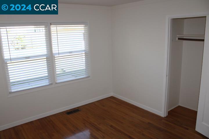 908 Everett Street El Cerrito, CA 94530 - Photo 19 of 27 a view of an empty room with wooden floor and a window