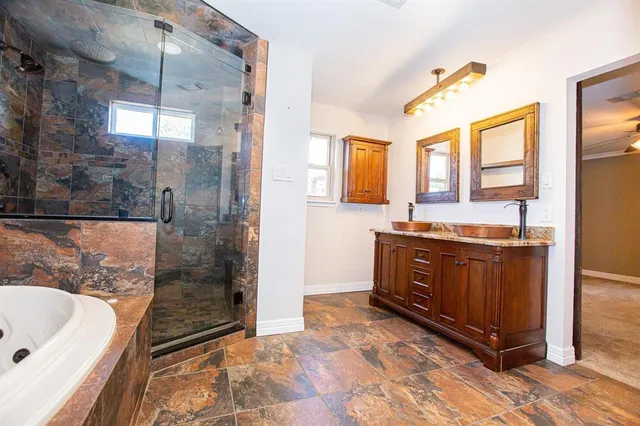 a bathroom with a granite countertop sink mirror and bathtub