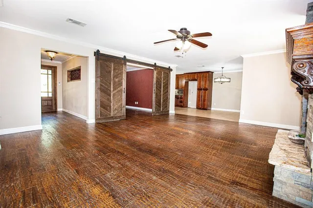 a view of a livingroom with wooden floor and ceiling fan