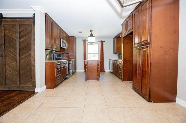 a kitchen with stainless steel appliances granite countertop a refrigerator and a stove top oven