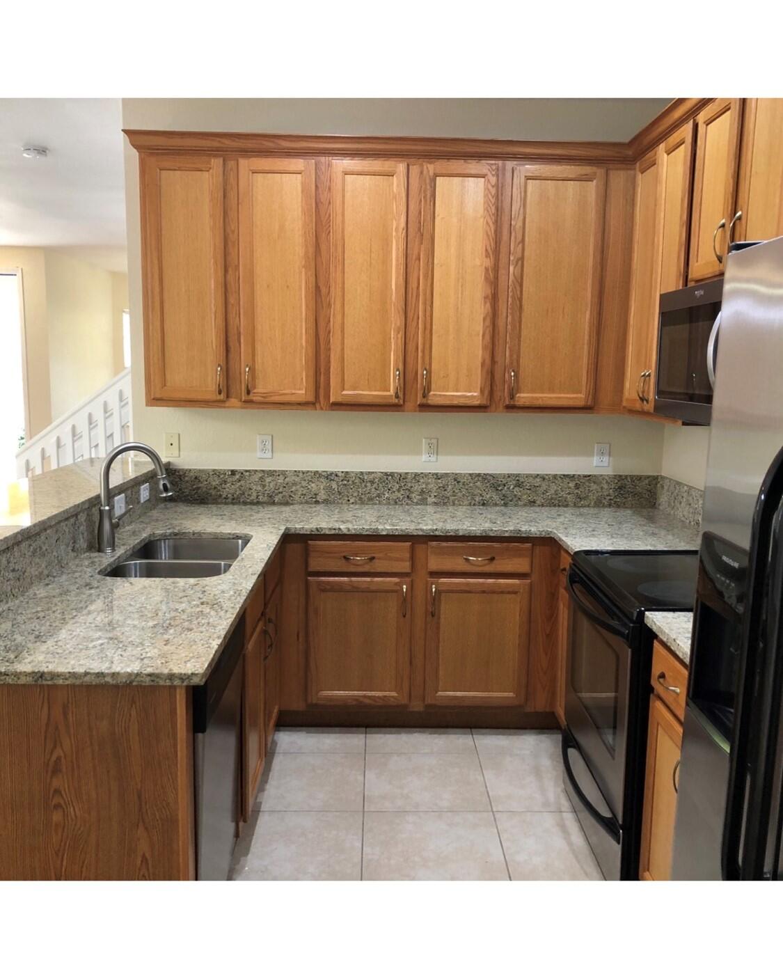 2031 Southeast Oldsmar Road Port St. Lucie, FL 34952 - Photo 7 of 14 a kitchen with granite countertop a sink dishwasher stove and cabinets