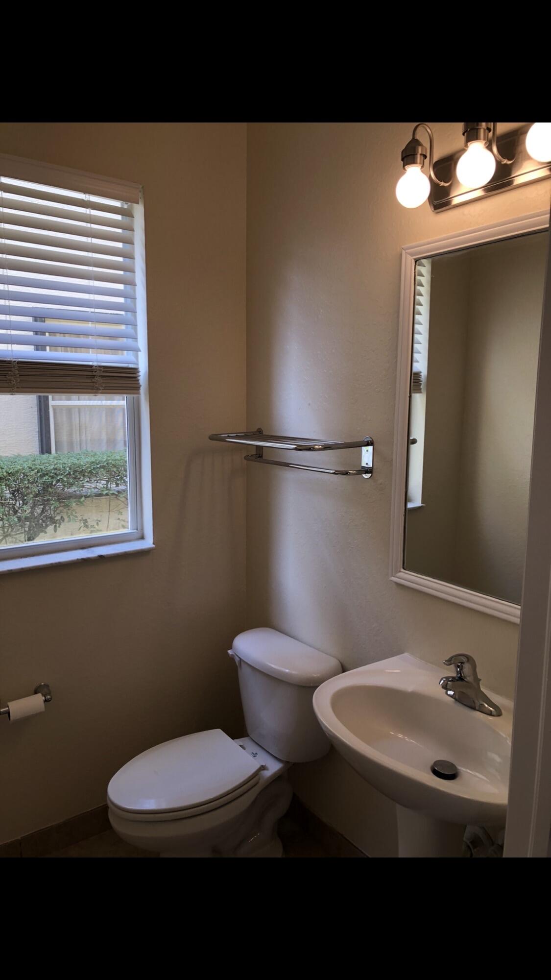 2031 Southeast Oldsmar Road Port St. Lucie, FL 34952 - Photo 10 of 14 a bathroom with a toilet sink and mirror