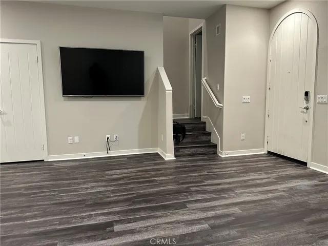 a view of an empty room with a tv and a window