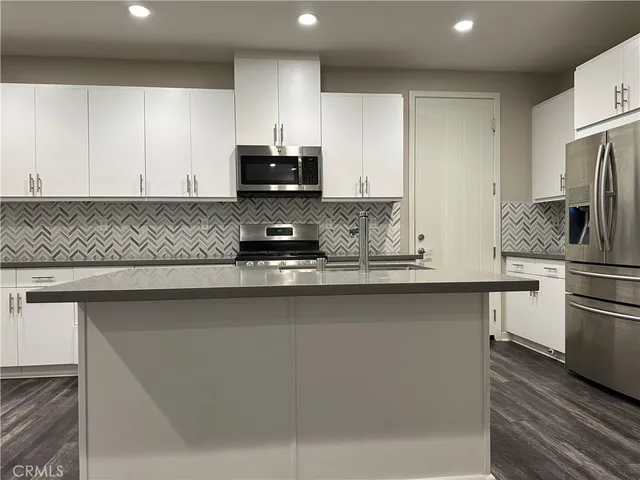 a kitchen with a sink cabinets and wooden floor