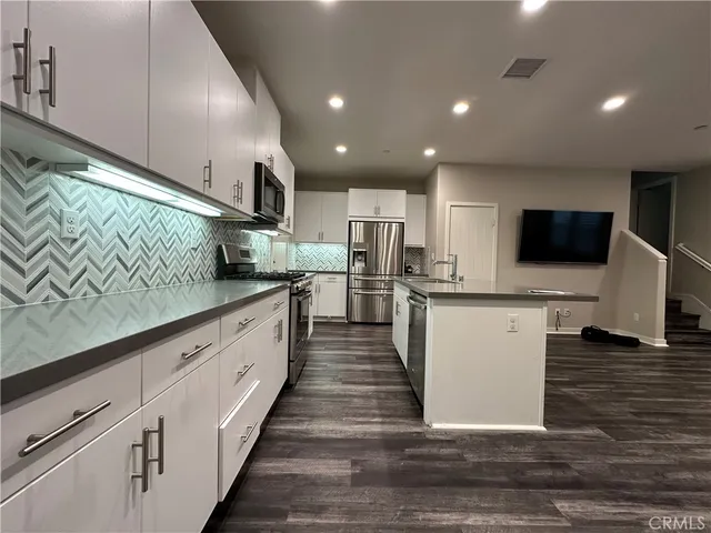 a kitchen with stainless steel appliances granite countertop a refrigerator and a stove