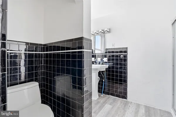 a bathroom with a toilet a sink and a mirror