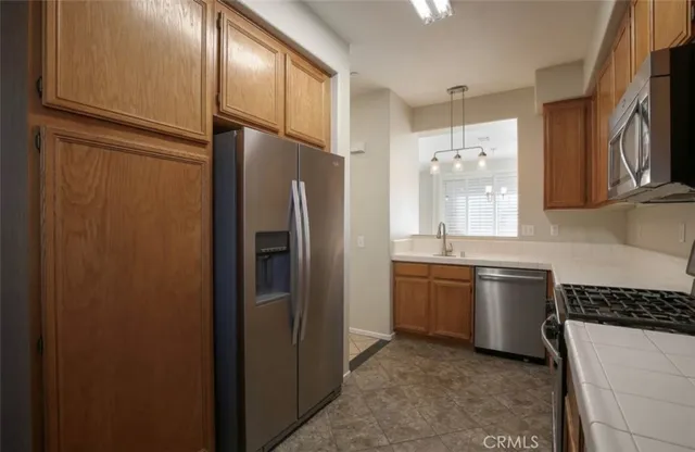 a kitchen with stainless steel appliances granite countertop a refrigerator and a sink