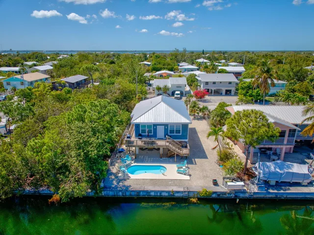 aerial view of a house with a garden and lake view