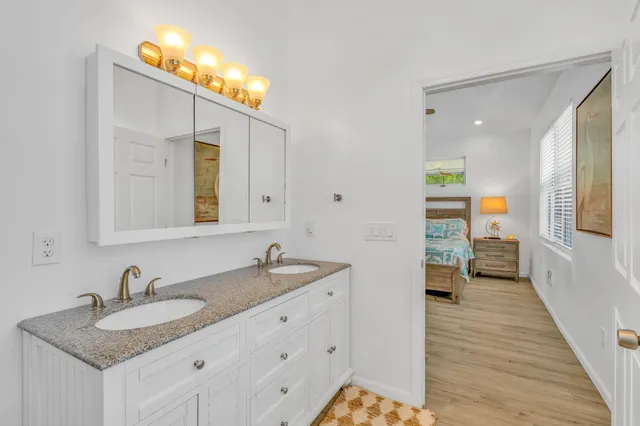 a en suite bathroom with a granite countertop sink and a mirror