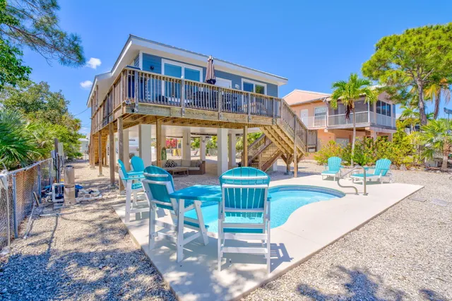 a view of a house with swimming pool and sitting area