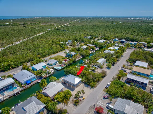 an aerial view of residential houses with outdoor space and lake view
