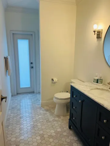 a bathroom with a granite countertop sink a toilet and a mirror