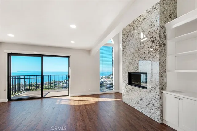 a view of empty room with wooden floor and fireplace