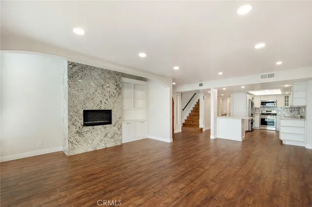 a view of empty room with wooden floor