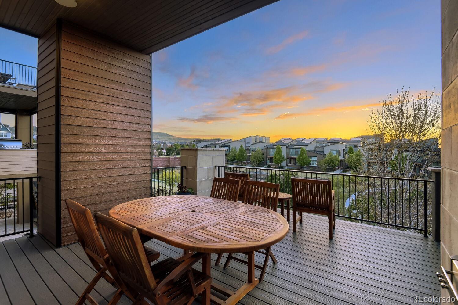 10155 Bellwether Lane Lone Tree, CO 80124 - Photo 34 of 45 a view of a roof deck with table and chairs a barbeque with wooden floor and fence