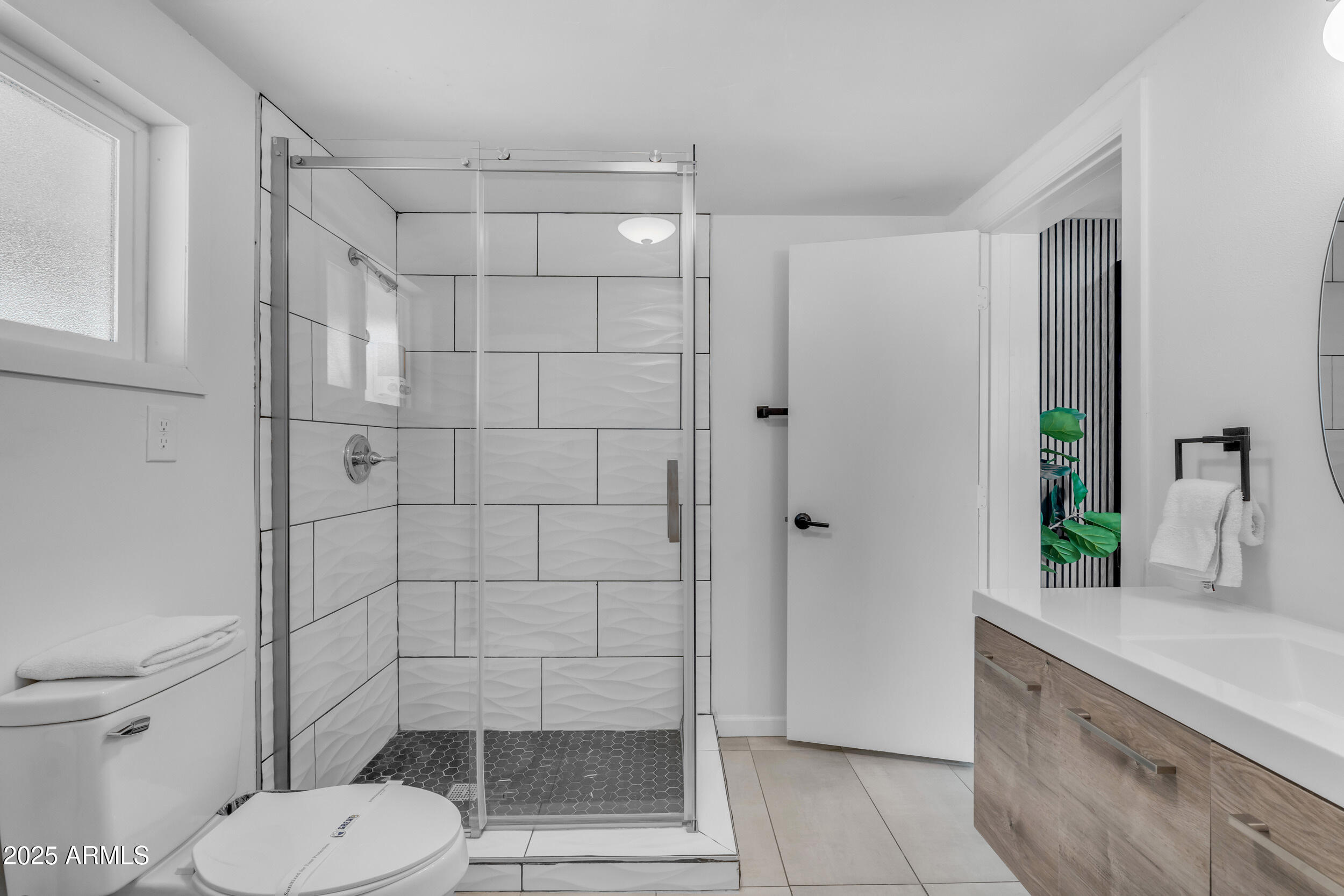 6943 East Granada Road Scottsdale, AZ 85257 - Photo 15 of 19 a bathroom with a granite countertop toilet a sink and shower
