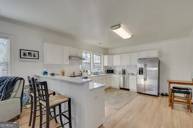 a kitchen with white cabinets and stainless steel appliances