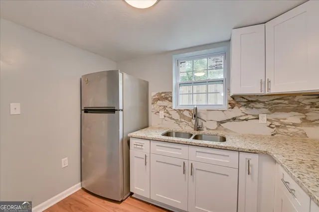 a kitchen with a refrigerator sink and cabinets