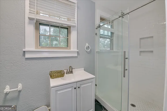 a bathroom with a sink a vanity and a shower