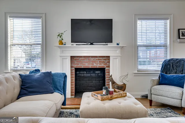 a living room with furniture a flat screen tv and a fireplace