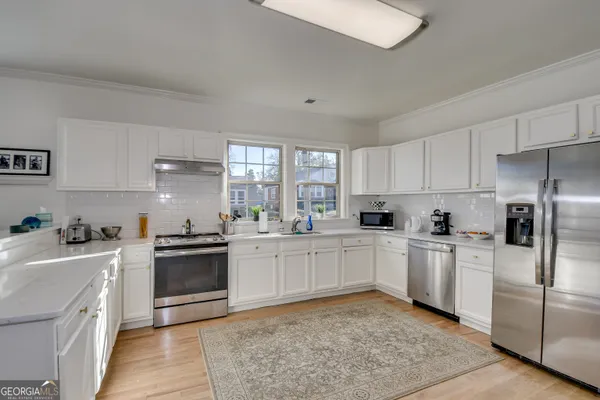 a kitchen with cabinets appliances and a window