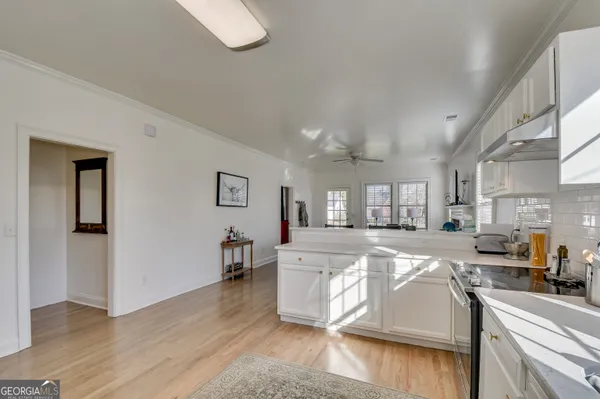 a large kitchen with cabinets wooden floor and a dining table