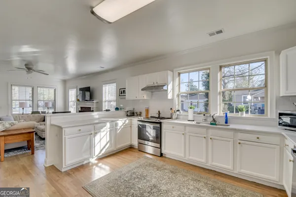 a kitchen with white cabinets and sink