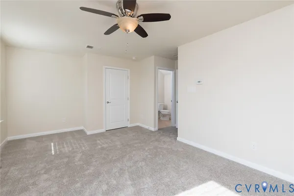 an empty room with a ceiling fan and a window