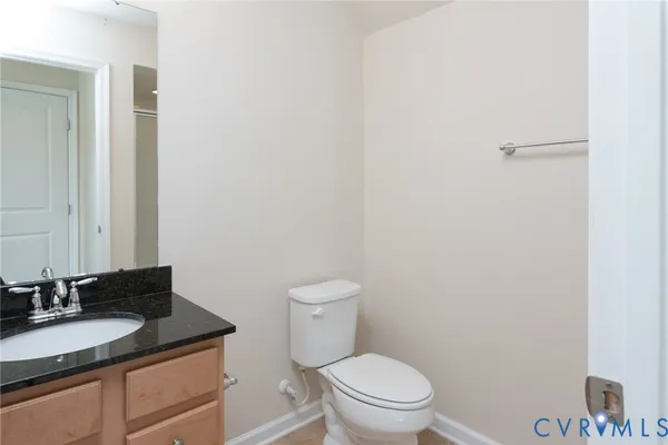 a bathroom with a granite countertop sink toilet and a mirror