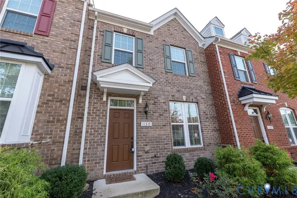 front view of a brick house with a small yard