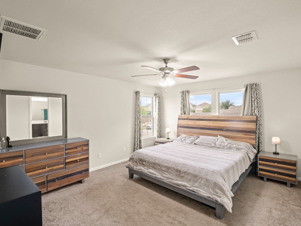 574 Nautical Loop Kyle, TX 78640 - Photo 11 of 23 a bedroom with a bed and a chandelier