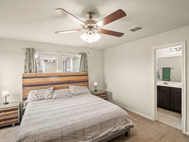 a bedroom with a large bed and a chandelier