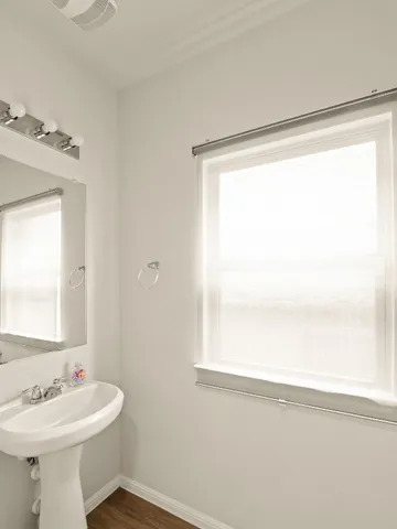 a bathroom with a sink mirror and a window