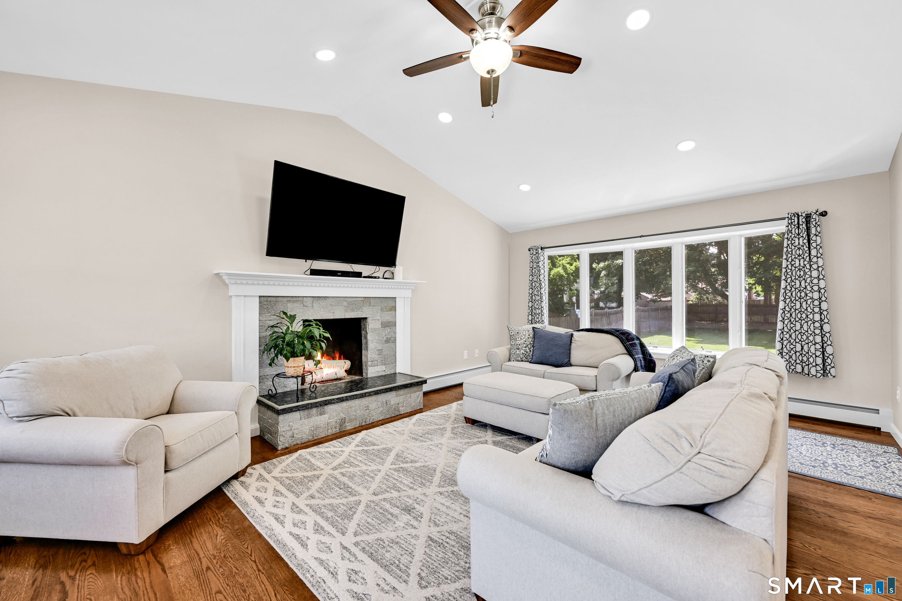 87 Lydall Road Newington, CT 06111 - Photo 7 of 35 a living room with furniture a flat screen tv and a fireplace