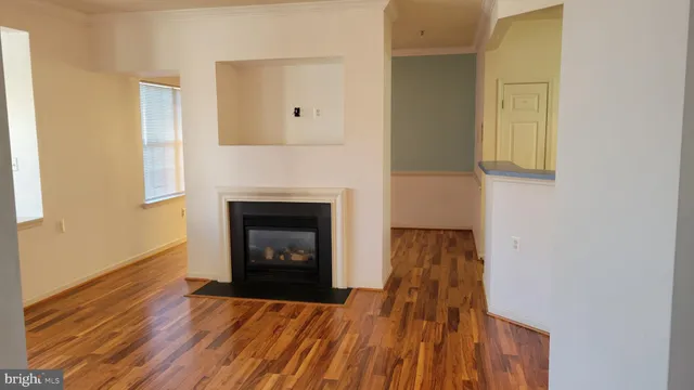 a view of a livingroom with wooden floor and a fireplace