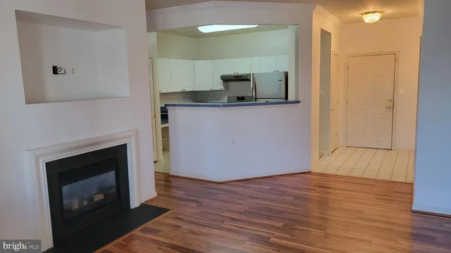 a view of a kitchen with wooden floor and a fireplace