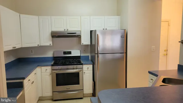 a kitchen with a stove top oven and refrigerator