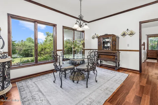 a dining room with wooden floor and a rug