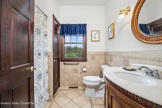 a bathroom with a sink a toilet and a mirror