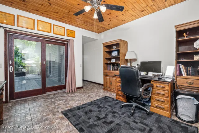 a view of a workspace with furniture and a window