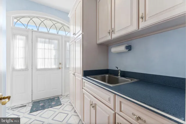 a large white kitchen with wooden floor and a sink