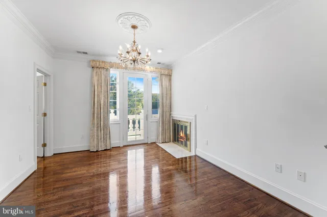 a view of an empty room with wooden floor and closet