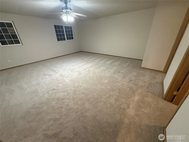 an empty room with closet and windows