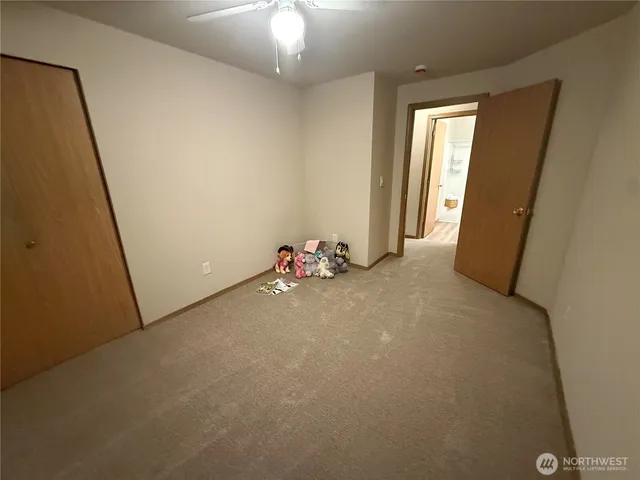 a view of a white bed in a bedroom next to a window
