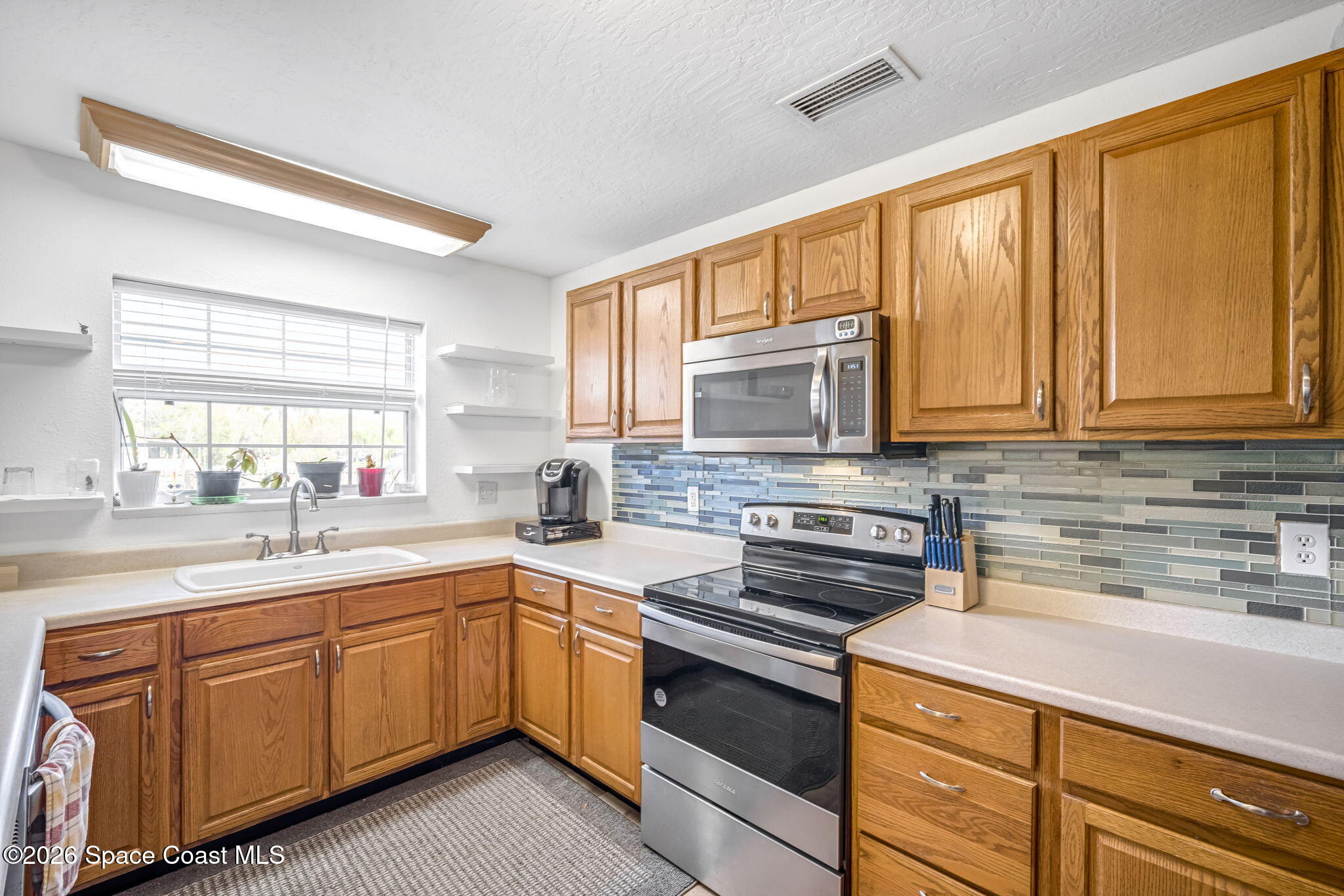 3404 Kilbee Street Mims, FL 32754 - Photo 11 of 30 a kitchen with a sink stove and cabinets