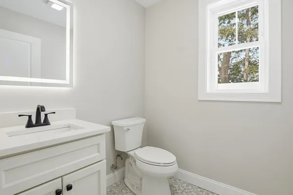 a bathroom with a sink a toilet and a window
