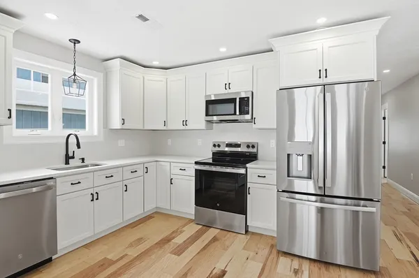 a kitchen with cabinets stainless steel appliances and sink